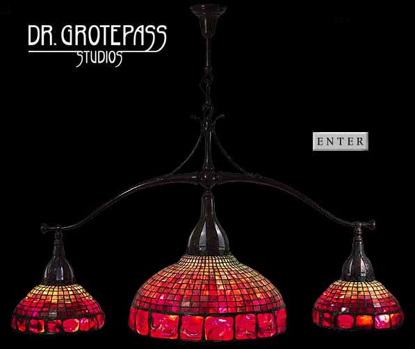 Pool table lamp, design of Tiffany Studios New York. Central geometric shade 21 1/2 & two satelite shades 12".                                             Lamp shades and Bronze hanging fixture made by Dr. Grotepass-Studios.  2008